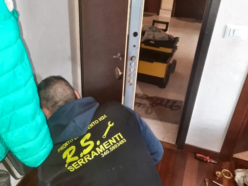 Un tecnico di R.S. Serramenti al lavoro sulla serratura di una porta blindata