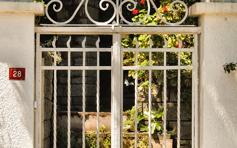 Cancello bianco in ferro battuto all'ingresso di una casa